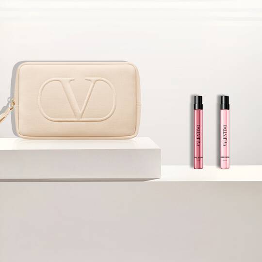 Beige Valentino-Tasche und zwei Valentino Born In Roma Donna Parfumproben auf weißen Podesten.