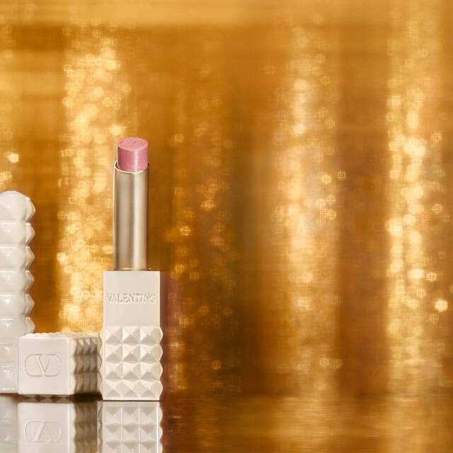 SPIKE VALENTINO IVORY vor einem Hintergrund aus schimmerndem Gold