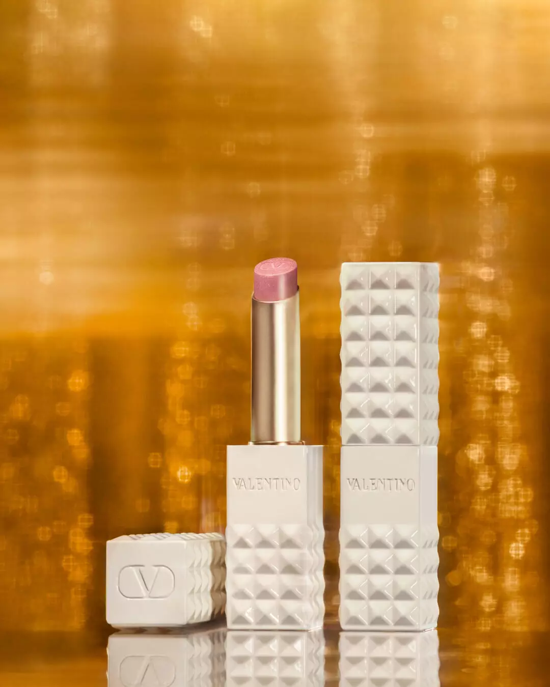 SPIKE VALENTINO IVORY vor einem Hintergrund aus schimmerndem Gold
